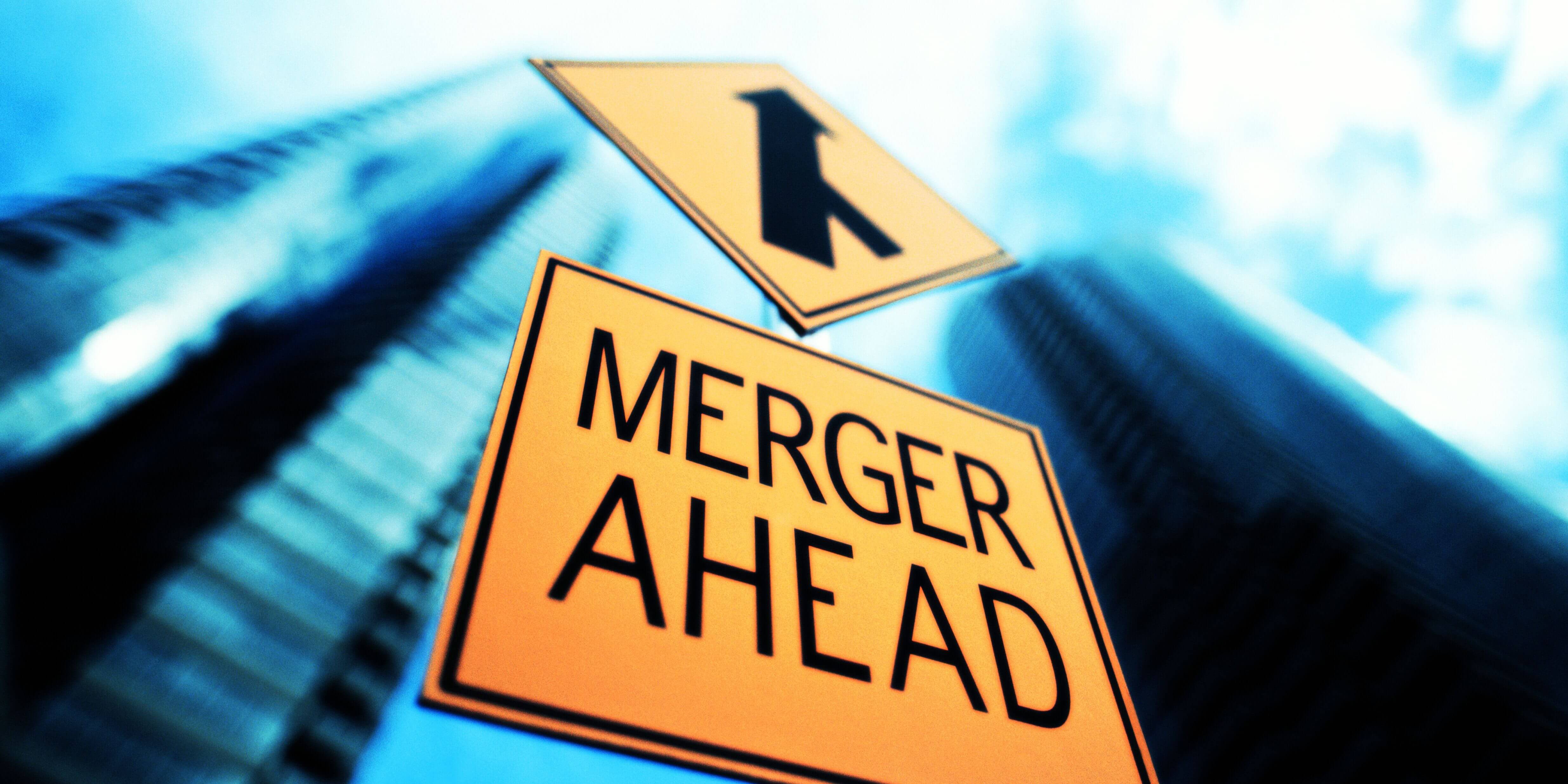 merger-sign-below-office-building